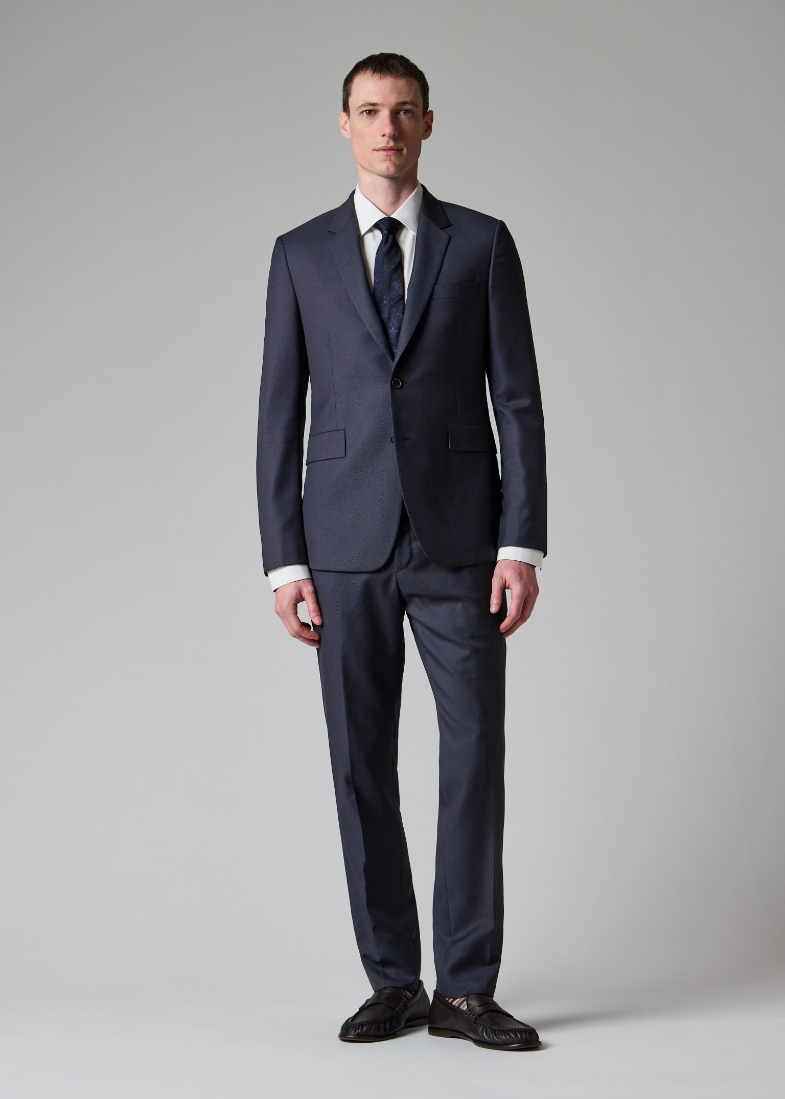 Male model wearing a dark navy Paul Smith Kensington slim-fit suit.