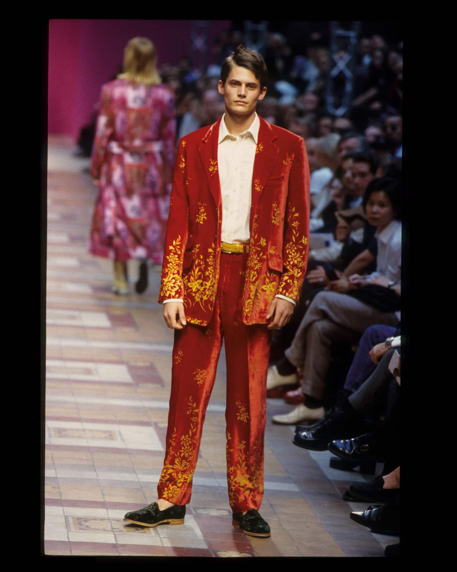 Model wearing a red Paul Smith velvet suit with yellow floral motifs.