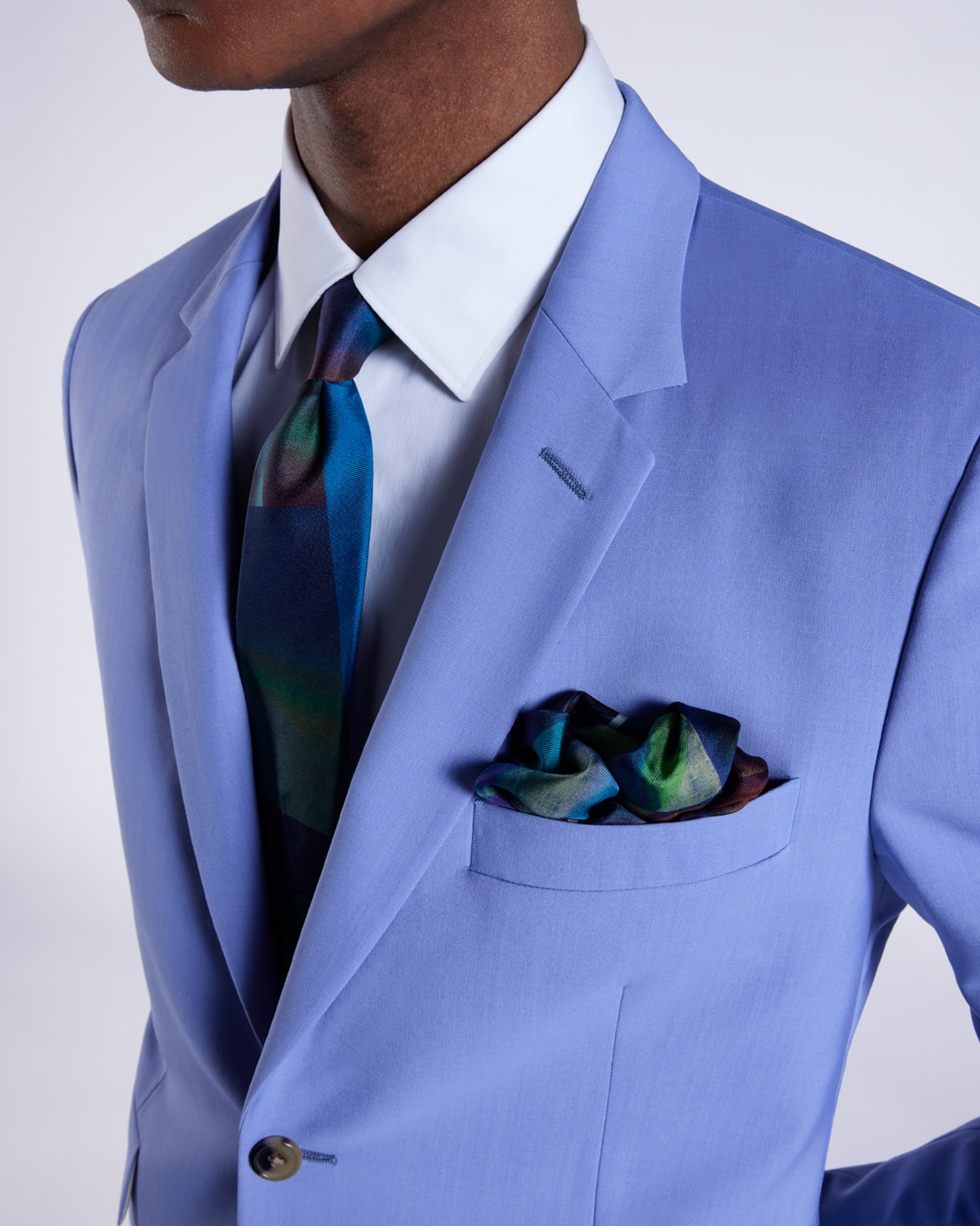 a male model wearing a light blue wedding suit jacket, white shirt and colourful patterned statement tie with matching pocket square